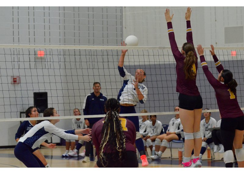 Sussex Academy junior Grayce Glover knocks the ball past the Milford block.